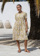 Woman wearing a 100% cotton floral short sleeve dress with round neckline. 