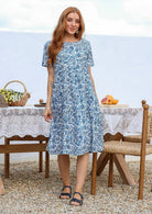 Woman wearing a 100% cotton white based floral midi dress with short sleeves.