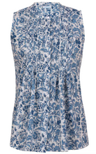 Sleeveless white based blue floral cotton top with button up collar, vertical small pleats and flared hem