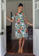 Woman wearing a 100% cotton relaxed fit dress with round neckline and short sleeves in colourful floral print.
