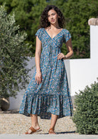 Model wearing 100 percent rayon maxi dress with elasticised cross-over bodice and tier at the bottom of the dress.