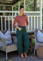 Woman wearing a cotton corduroy wide-leg dark green pants with hand in pockets