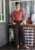 Woman posing in cotton corduroy wide-leg dark brown pants with hand in pockets