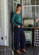 Woman standing sideways wearing cotton corduroy wide leg pants in navy blue, paired with basic rayon top 