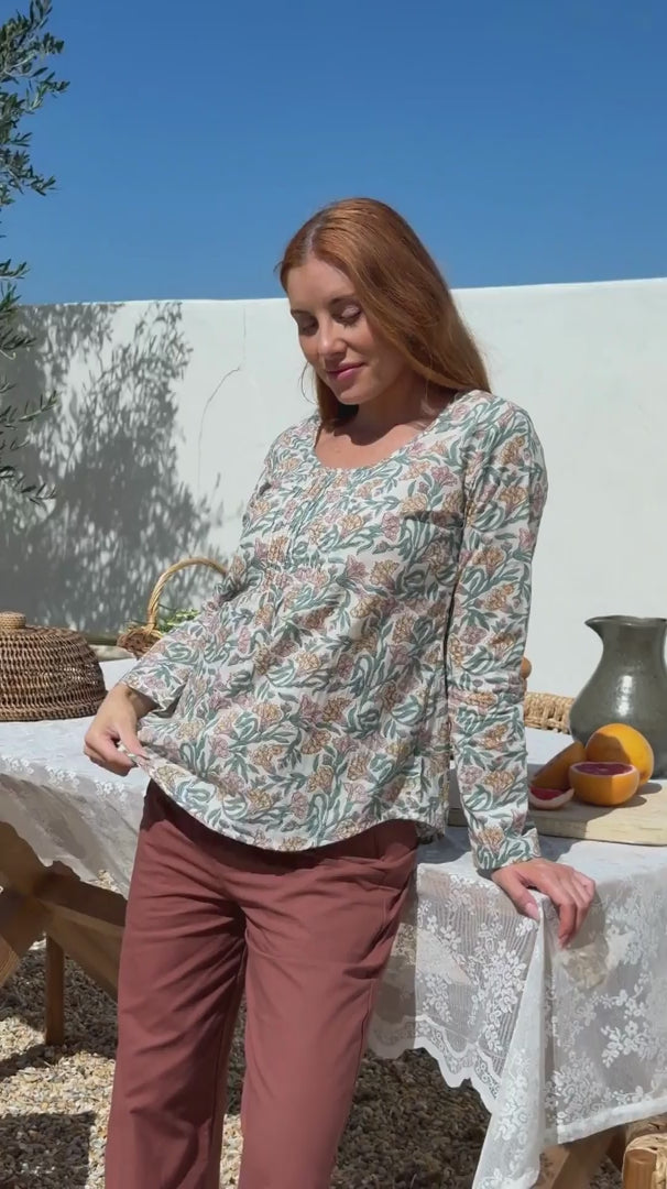 Video of a model wearing 100% cotton long sleeve top with round neckline and tiny pleat detail from the center of the neckline.