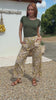 Video of a model wears cream wide-leg trousers with yellow floral print, olive T-shirt, tan sandals, outdoor setting.