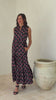 Video of woman wearing a 100% cotton black floral tiered maxi dress with sleeveless design and notch neckline. 
