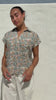 Video of a woman poses in relaxed fit cotton short sleeve top with rolled cuffs sleeves, collar and V neckline.