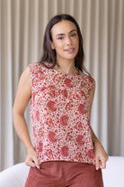 Woman wears 100% cotton gentle cream based floral print cotton sleeveless top with small gathers across the bust
