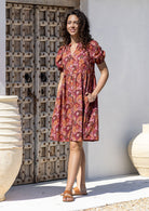 Woman wearing a knee length relaxed fit button through 100% cotton dress with elbow length sleeves