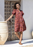 Woman wearing a warm toned Japanese style print dress with pink, maroon, brown, peach and khaki palette. 
