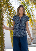 Woman wearing a 100% cotton navy blue based floral blouse and plain pants. 