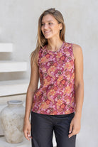 Woman wearing a sleeveless Japanese style floral print cotton top with round neckline in an outdoor setting