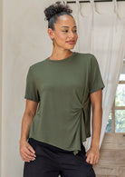 Woman wearing an olive green twist-front rayon T-shirt with short sleeves and a subtle draped knot at the front.