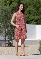 Woman in a Japanese style floral print sleeveless above knee dress with hand in pocket