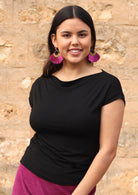 Woman wearing a wide neck mod black stretch rayon boat neck top