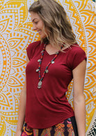 Woman wearing a maroon v-neck short cap sleeve rayon top