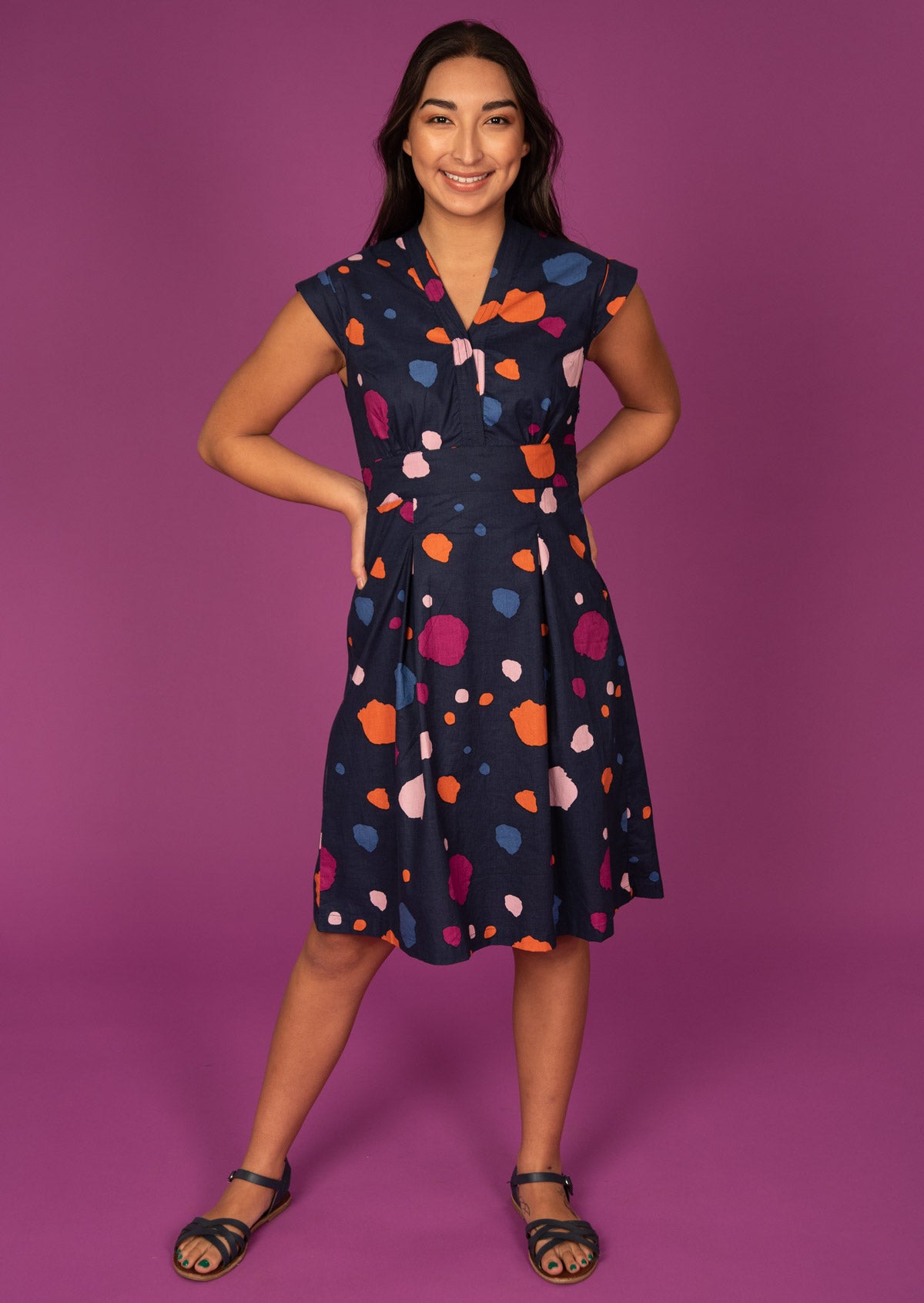 Model poses in V-neck Knee Length retro inspired Dress with cap sleeves and structured bodice