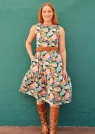 Red haired model in midi dress with pockets worn with belt and leather boots