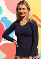 Woman wearing a round neck navy blue long sleeve rayon top.