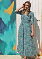 Model wears floaty rayon maxi dress with buttoned bodice, V-neckline, 3/4 sleeves and ruched waistband.