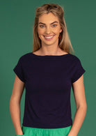 Woman wearing a wide neck mod navy blue stretch rayon boat neck top